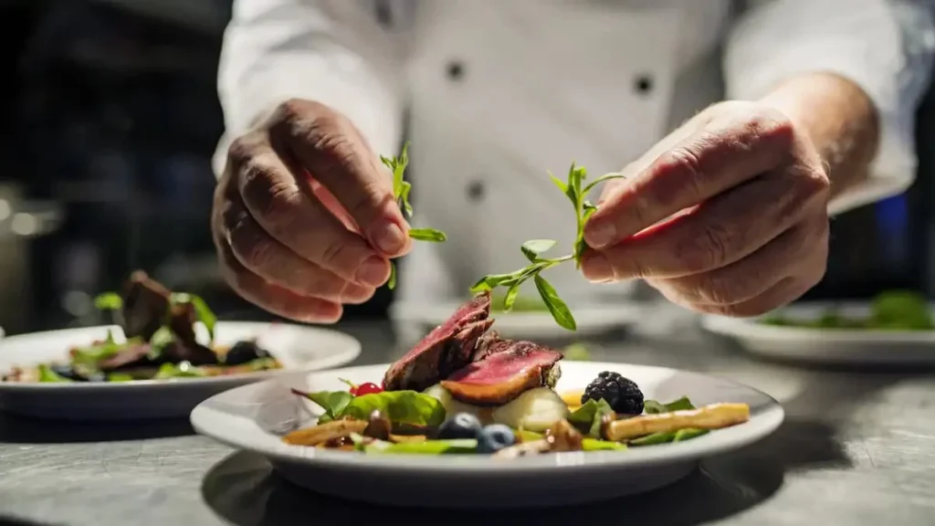 Chef privé dressant un plat gastronomique pour un service de conciergerie